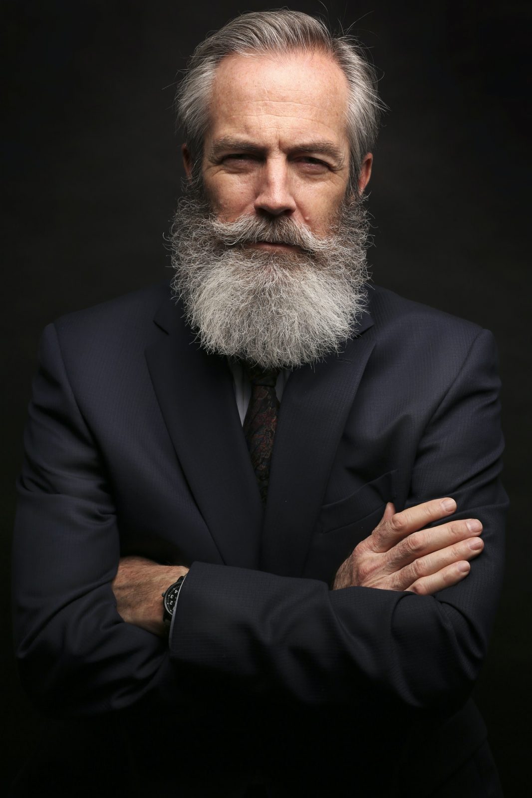 mature male model wearing suit with grey hairstyle and beard